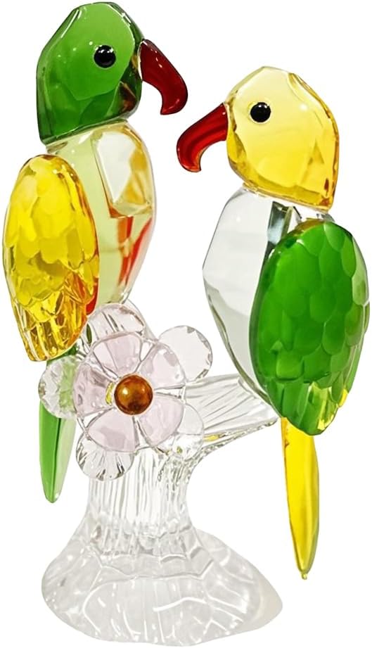 Two green and yellow glass parrots on a clear branch-style base