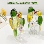 Green and yellow glass parrot pair ornaments on clear branch-style bases