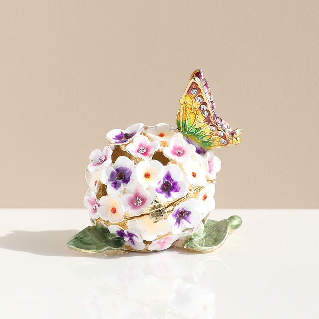 Side view of floral enamel box with gold-toned outlines