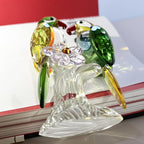 Angled view of glass parrot pair and flower-shaped accent