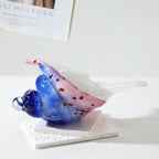 Side view of a blue and pink glass conch shell sculpture