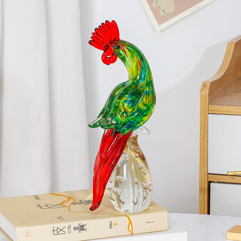 Glass rooster figurine displayed on a stack of books