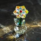 Sunflower glass ornament on a dark patterned surface