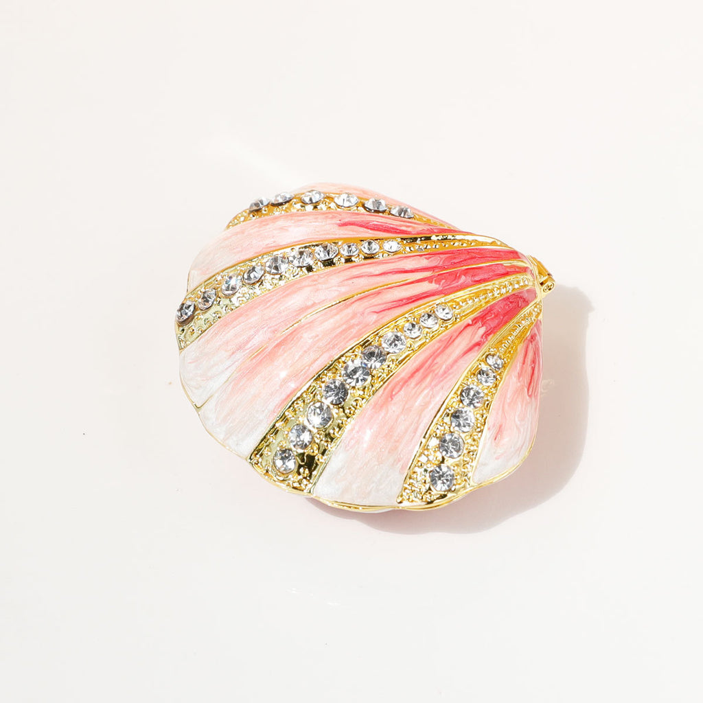 Pink shell jewelry box with gold-toned ridges and decorative accents