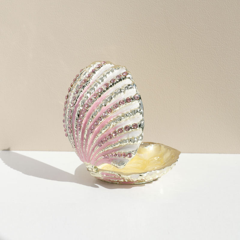 Open pink shell jewelry box viewed from the side