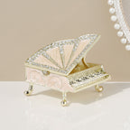 Pink grand piano jewelry box with gold-toned trim and raised lid