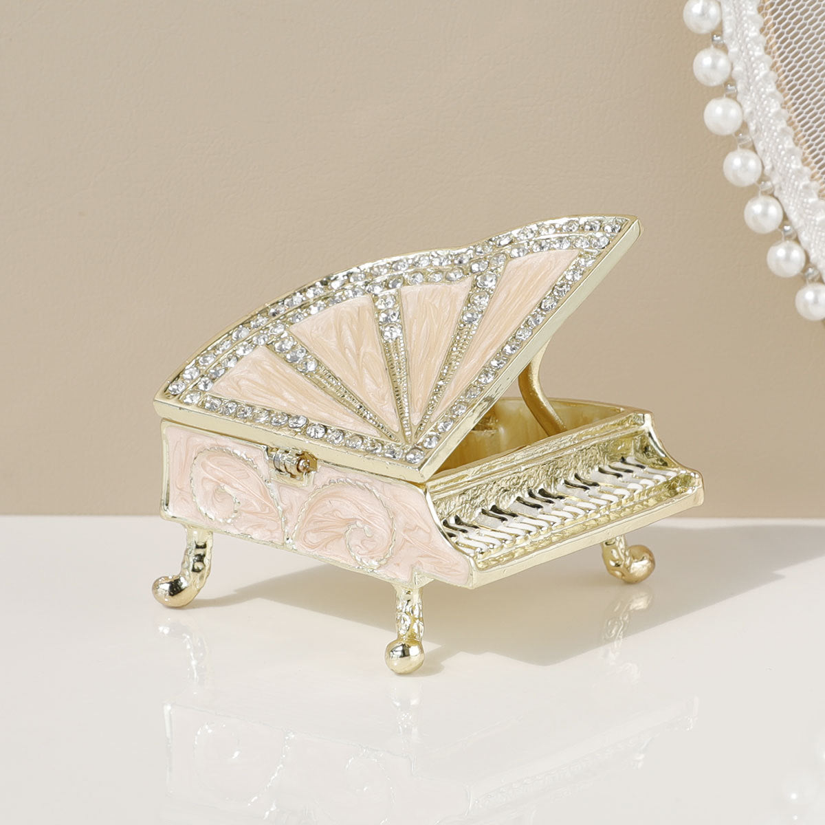 Pink grand piano jewelry box with gold-toned trim and raised lid