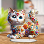 Blue-eyed floral kitten ornament on a wooden tabletop