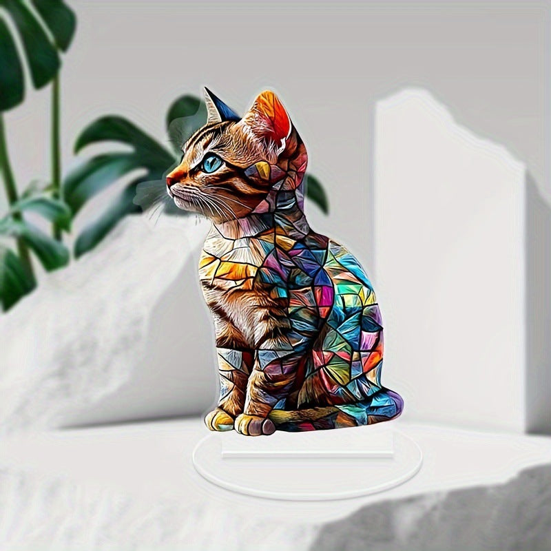 Cat acrylic ornament on a white display surface beside greenery