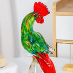 Close view of green glass rooster figurine with red crest and tail