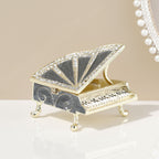 Black piano-shaped jewelry box shown with its lid raised
