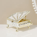 White grand piano jewelry box with decorative accents and raised lid