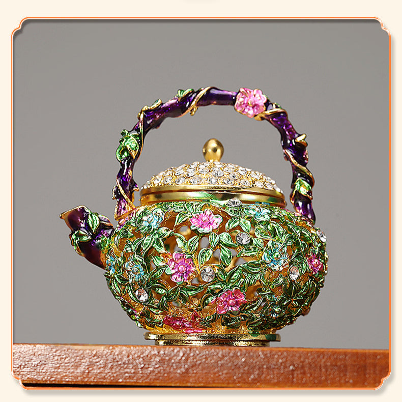 Floral teapot trinket box with purple handle on a wooden surface